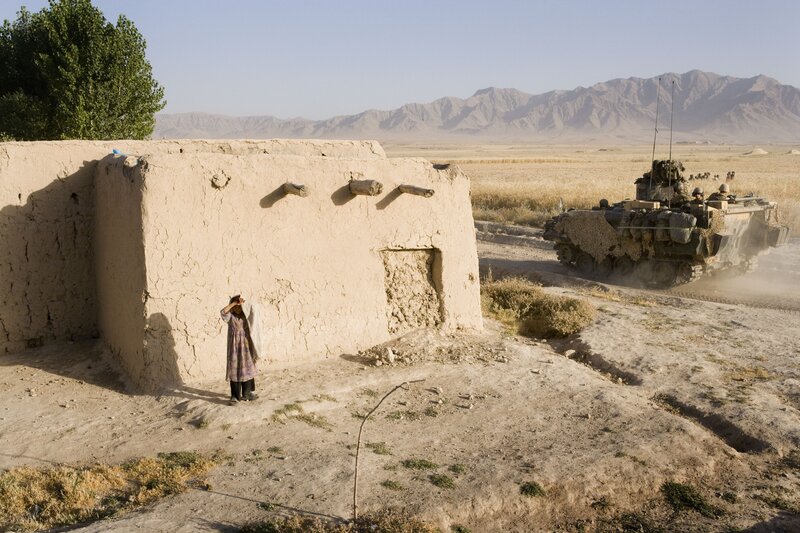 Soldiers pass a village house