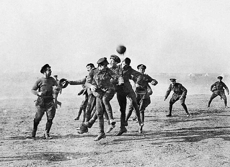 Soldiers playing football in a field