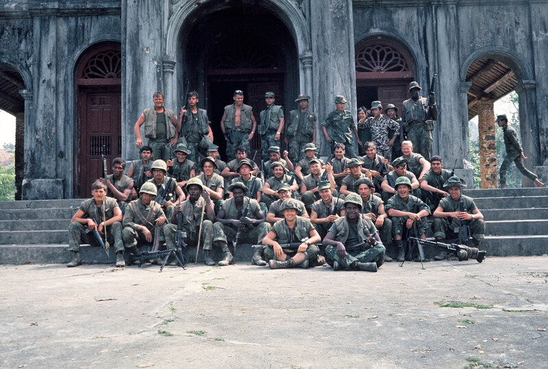 Soldiers pose in front of building