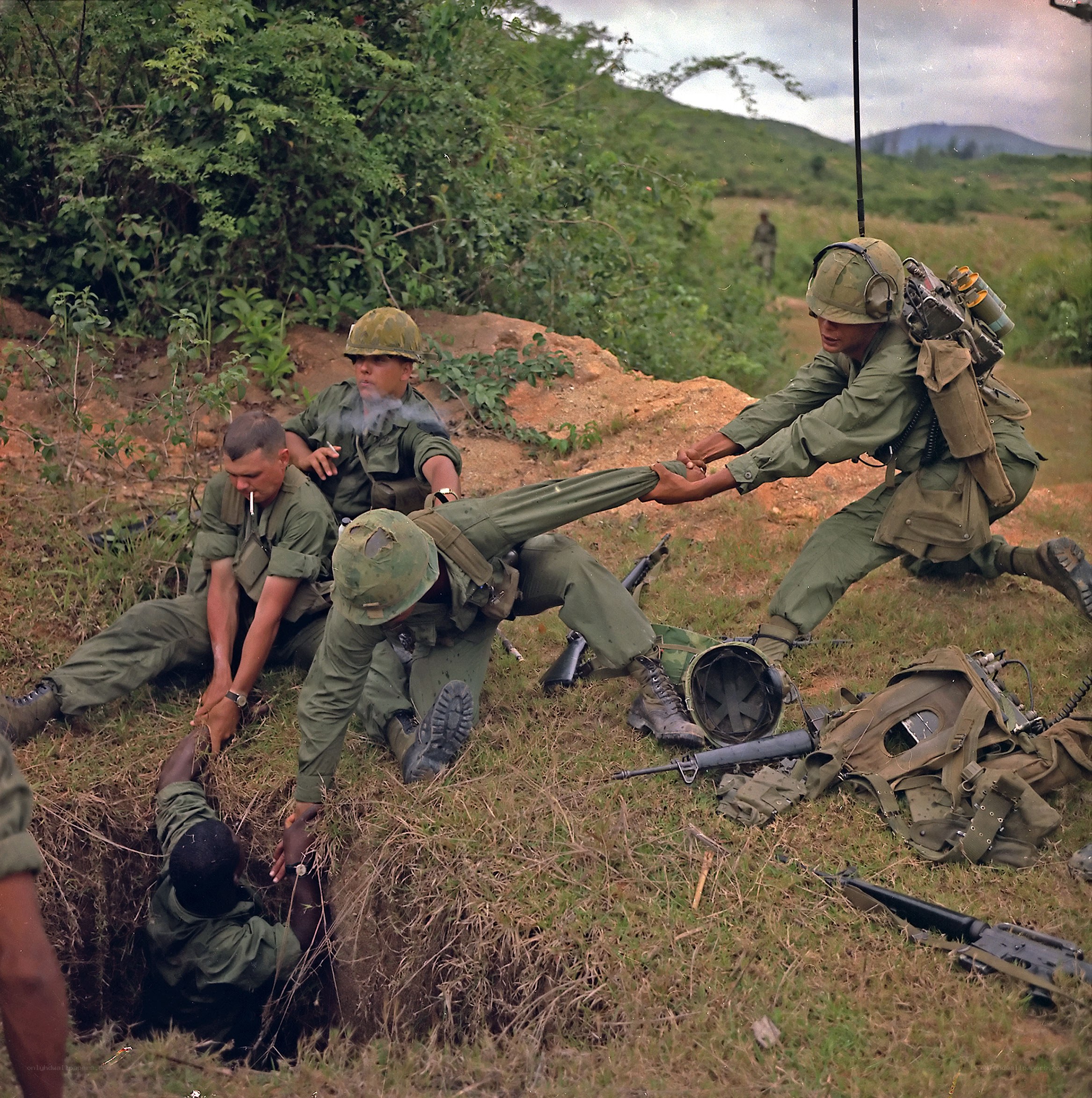 Soldiers pulling comrade from hole