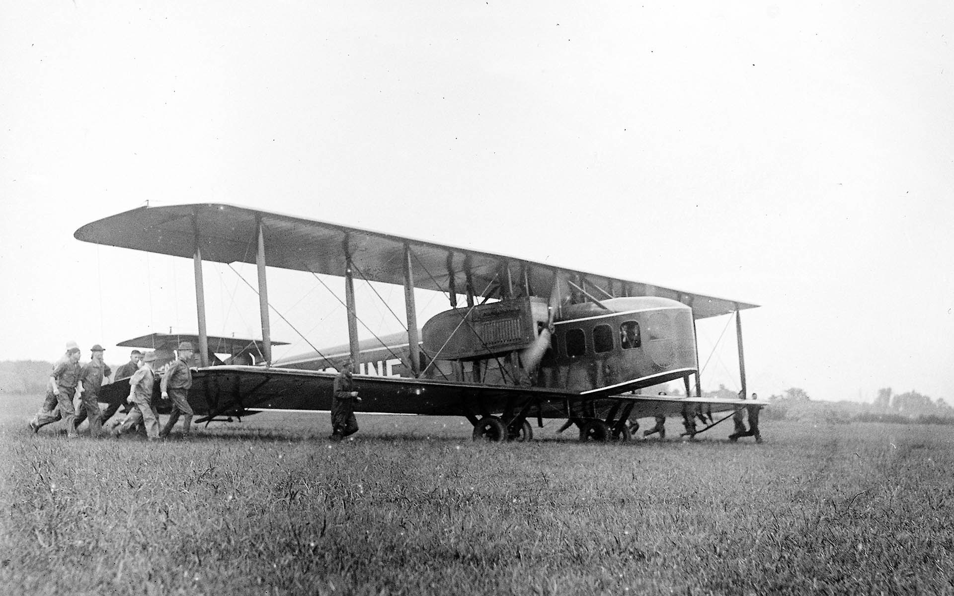 Soldiers pushing a biplane