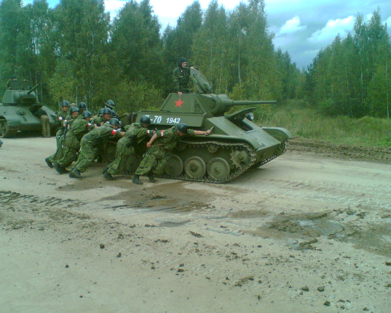 Soldiers pushing a tank