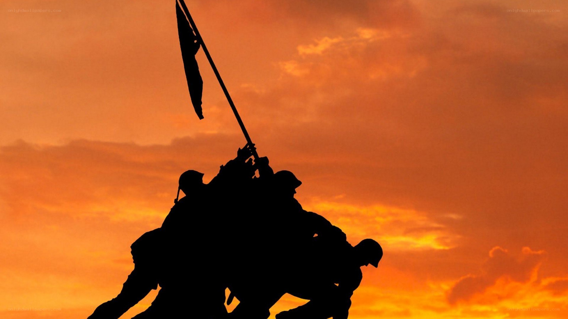 Soldiers raising flag at sunset