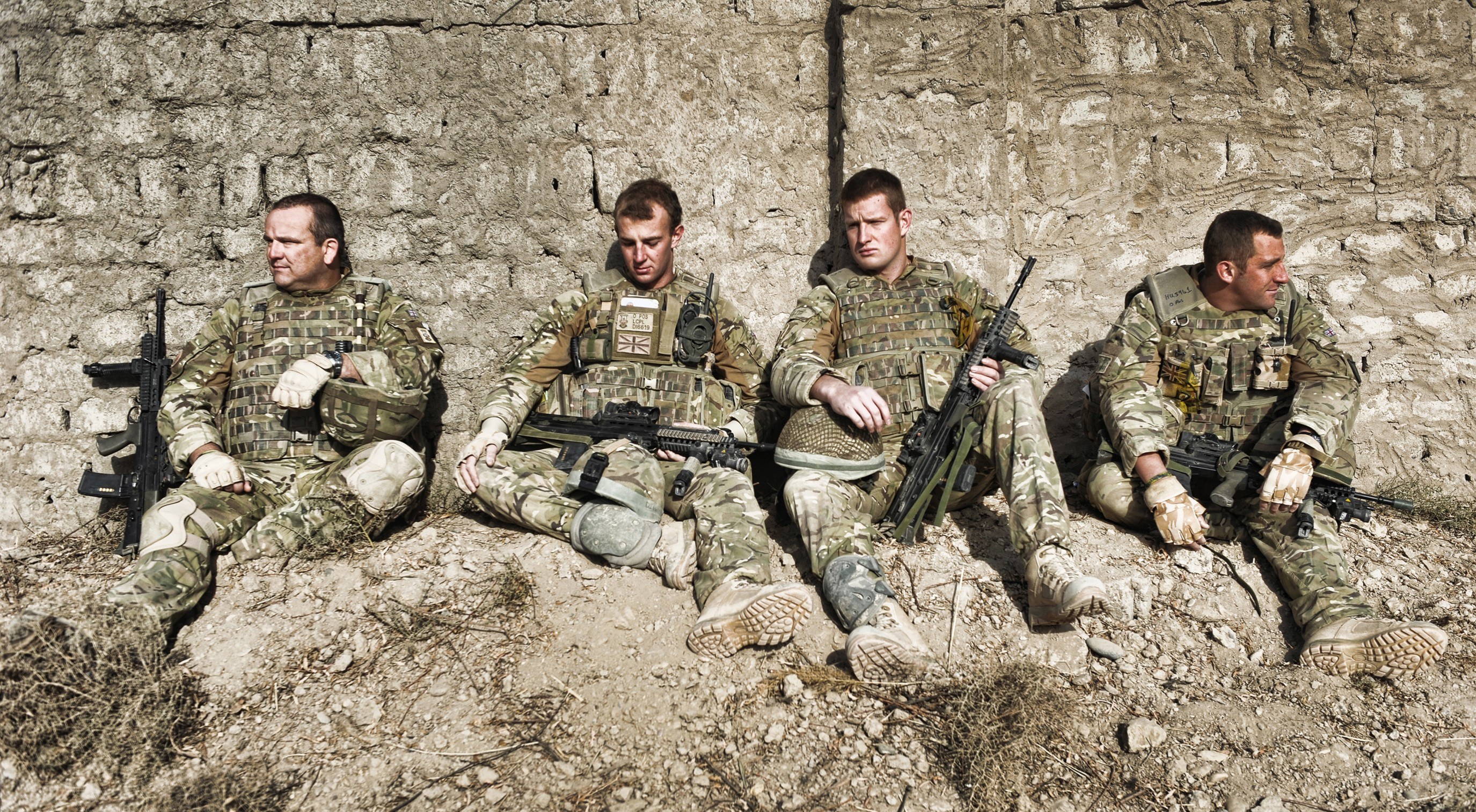 Soldiers resting against a wall