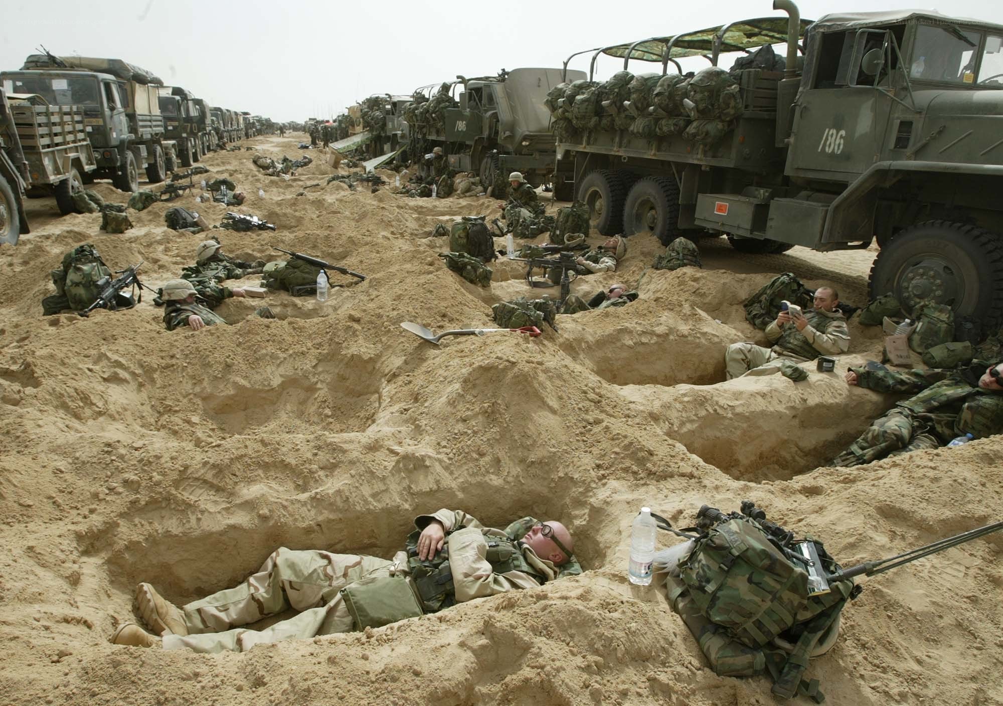 Soldiers resting in sand trenches