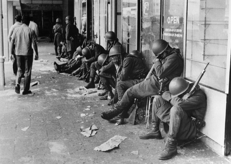Soldiers resting on a city street