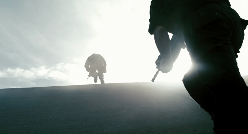 Soldiers silhouetted against bright sky