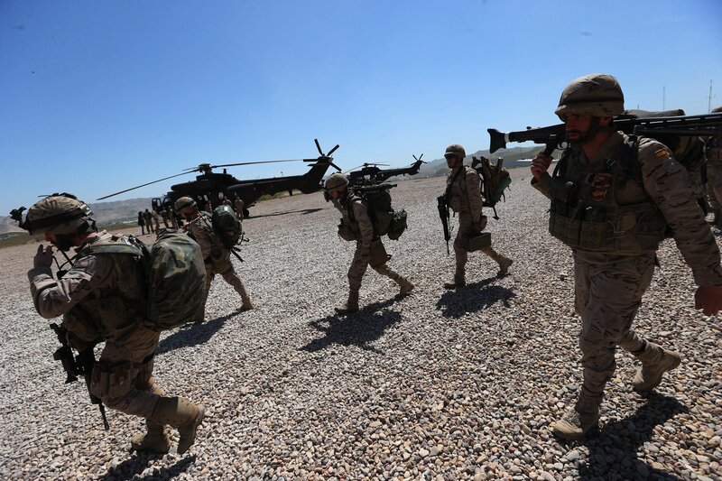 Soldiers walking near helicopters