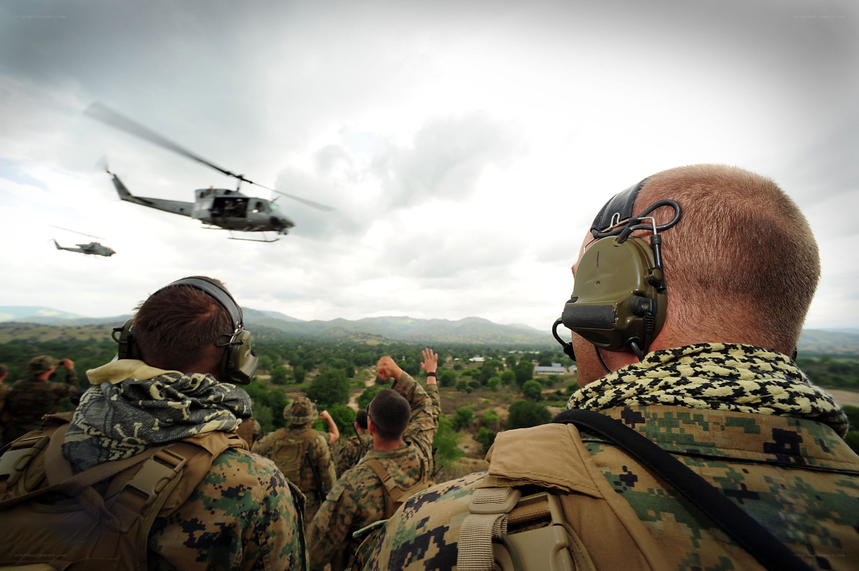 Soldiers watching helicopters arrive