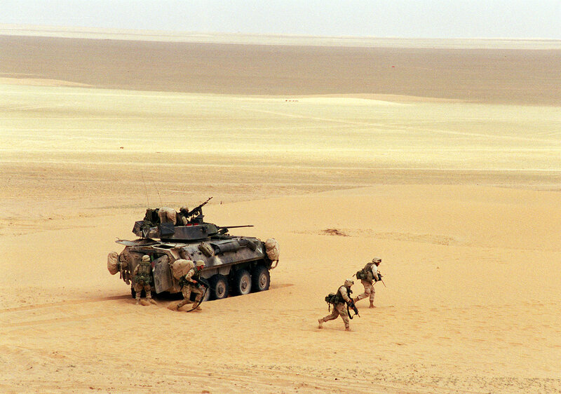 Soldiers with armored vehicle in desert