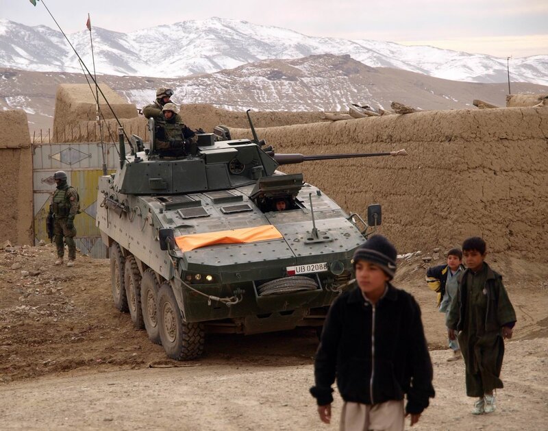 Soldiers with armored vehicle in mountain village