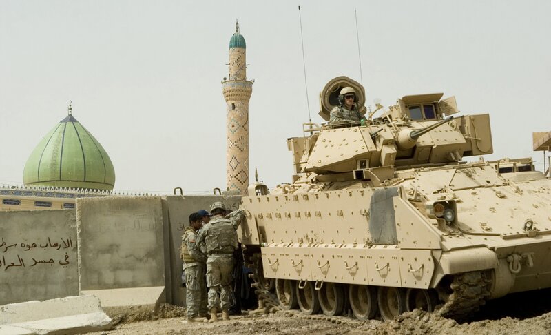 Soldiers with armored vehicle near mosque