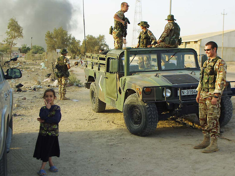 Soldiers with child near military vehicle