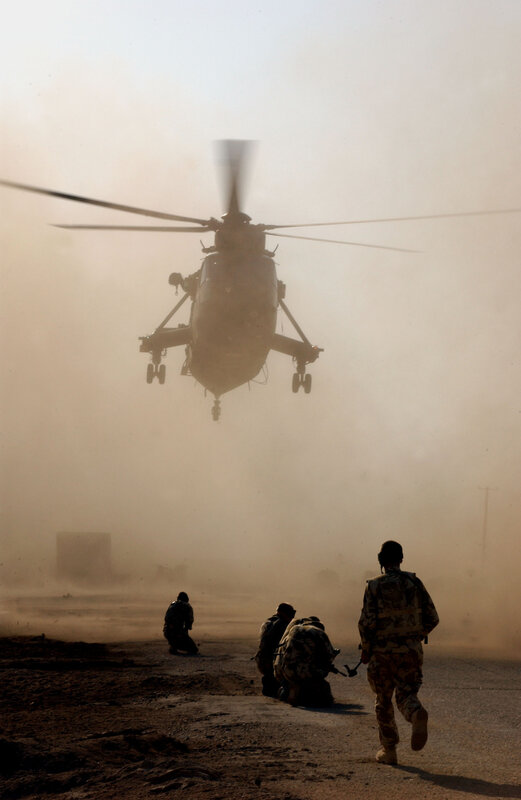 Soldiers with helicopter in dust