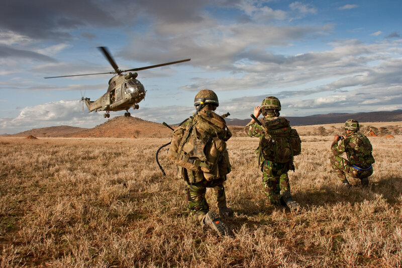 Soldiers with helicopter in field