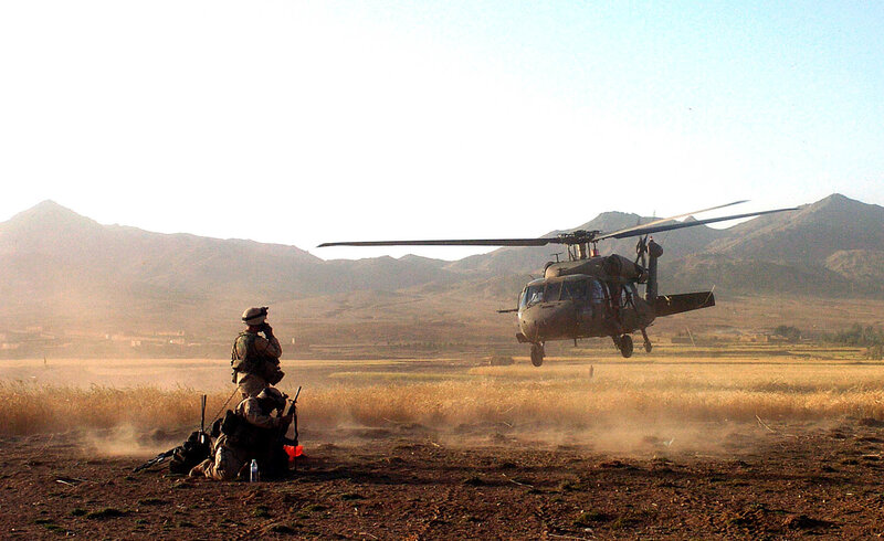 Soldiers with helicopter in field