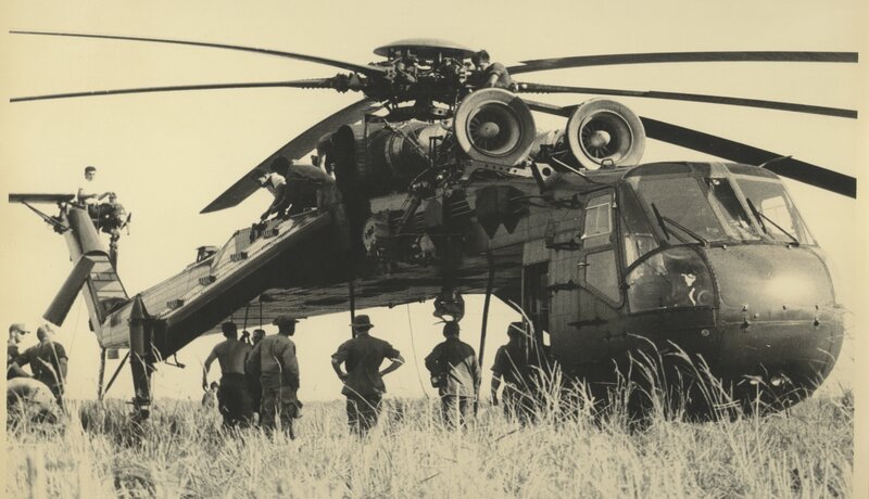 Soldiers with helicopter in field