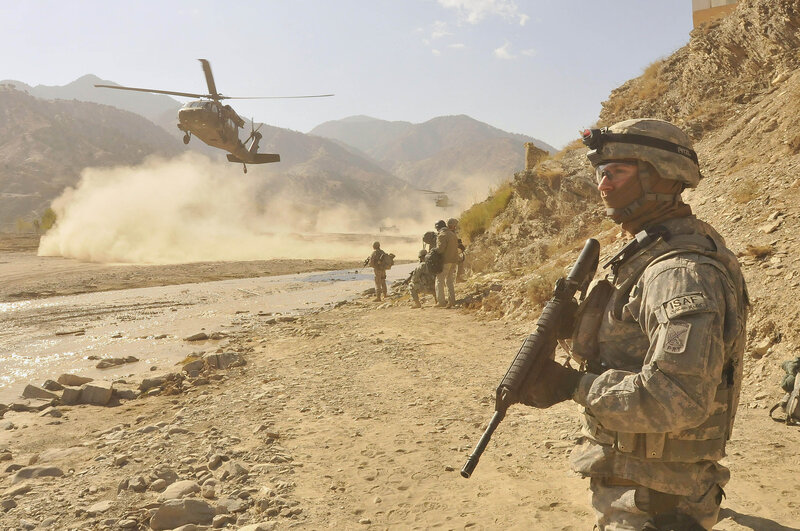 Soldiers with helicopter in mountain valley