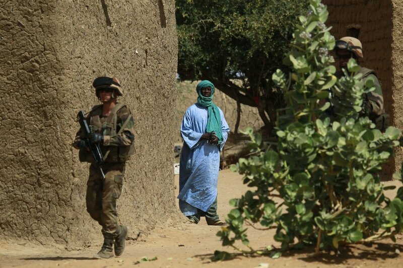 Soldiers with local man in village