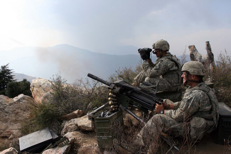 Soldiers with machine gun on hillside