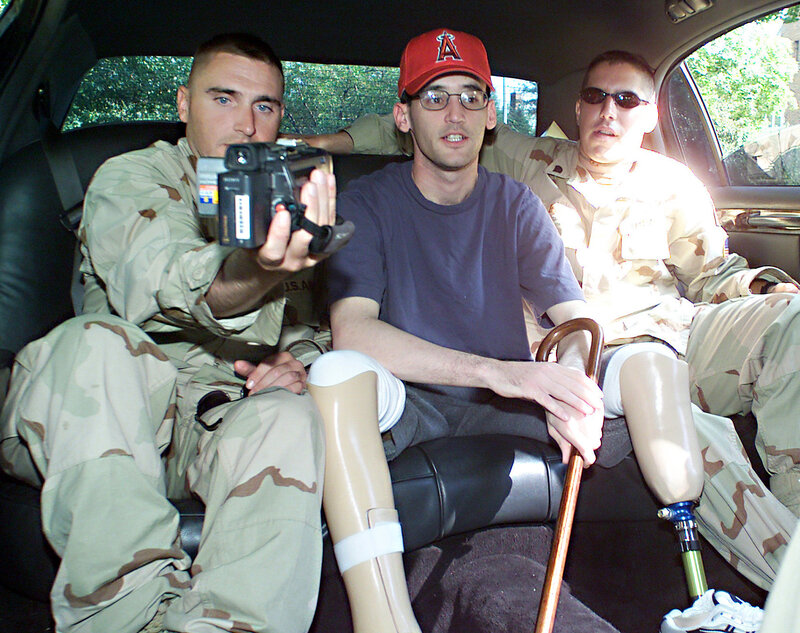 Soldiers with prosthetic legs in car