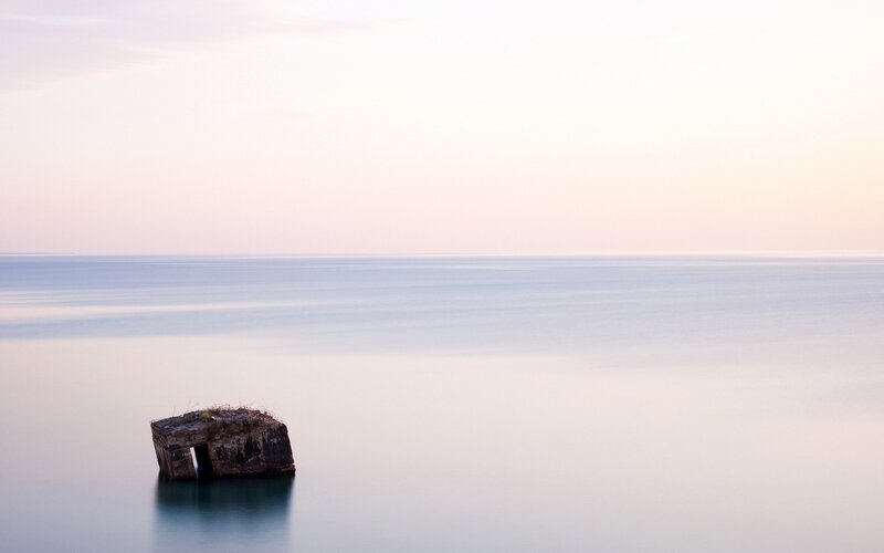 Solitary rock in calm sea