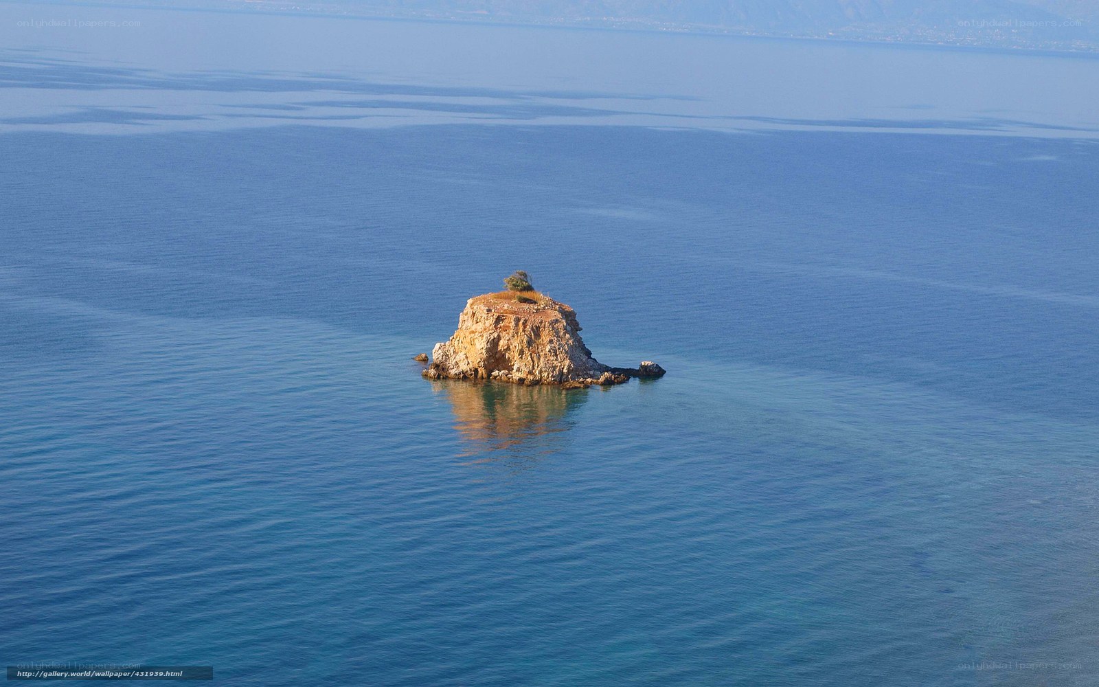 Solitary rock island in blue sea