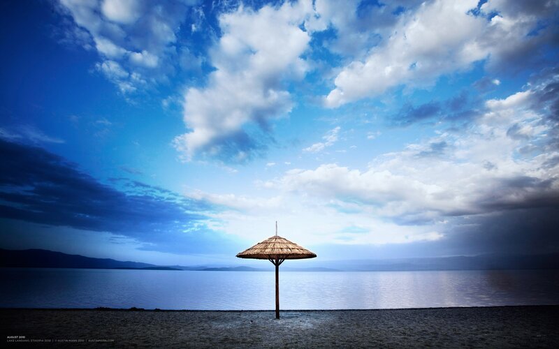 Solitary umbrella on a lake shore