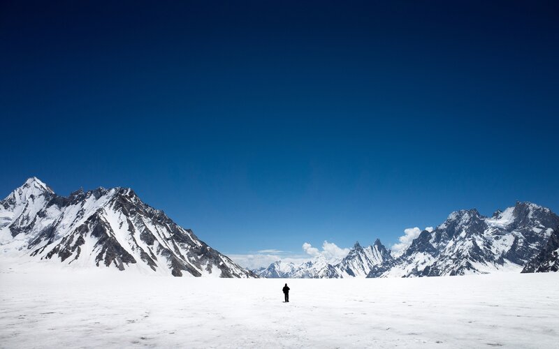 Solo hiker on snowy mountain plateau
