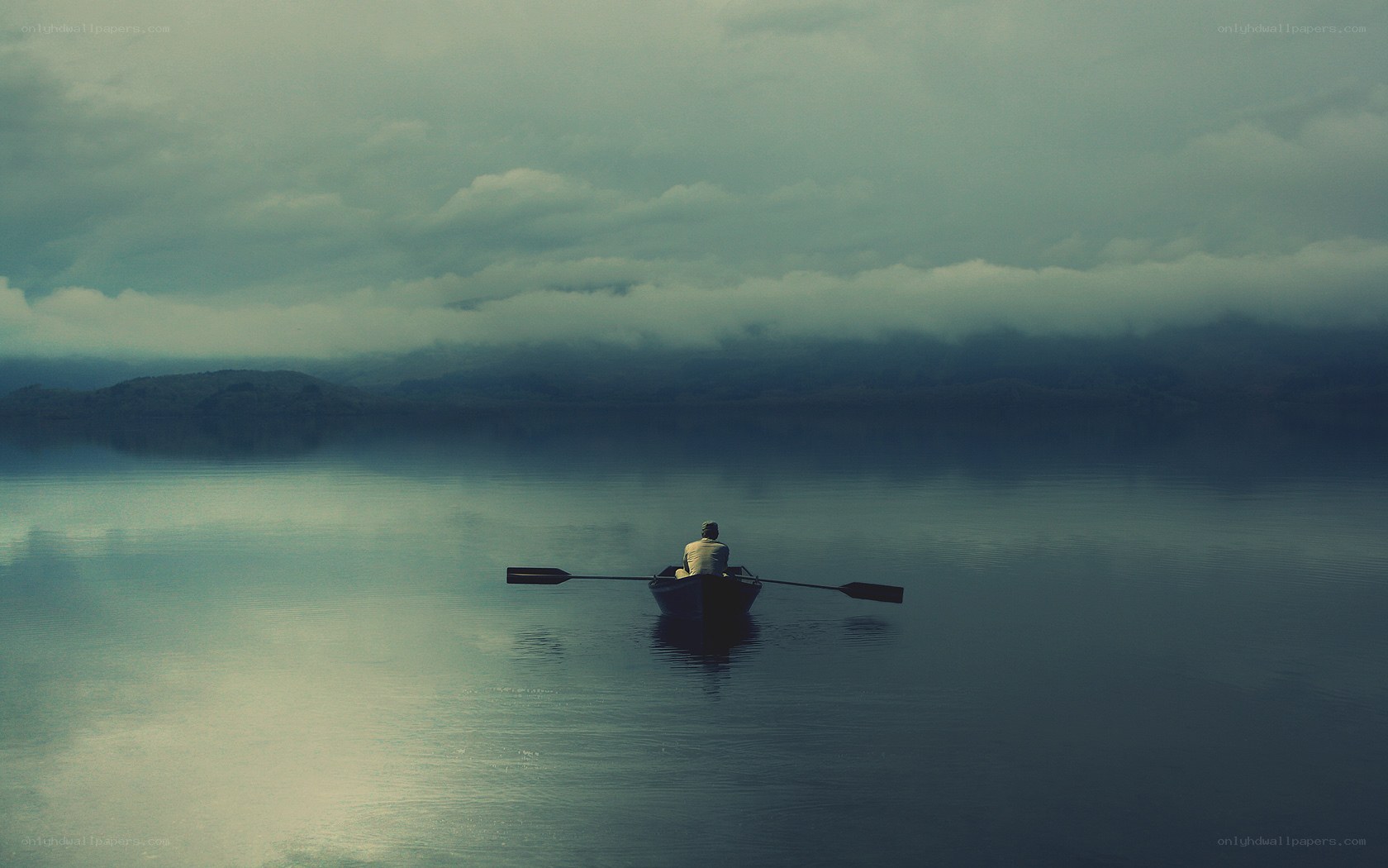 Solo rower on a misty lake