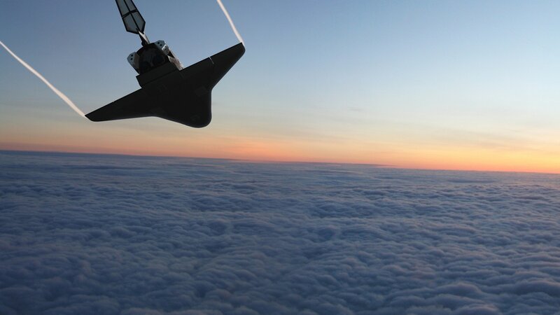 Space shuttle above clouds