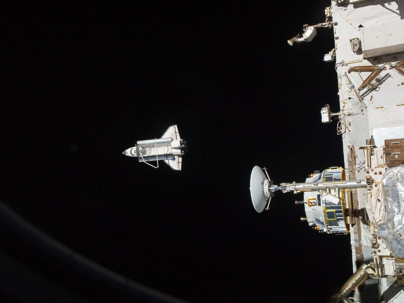 Space shuttle approaching space station