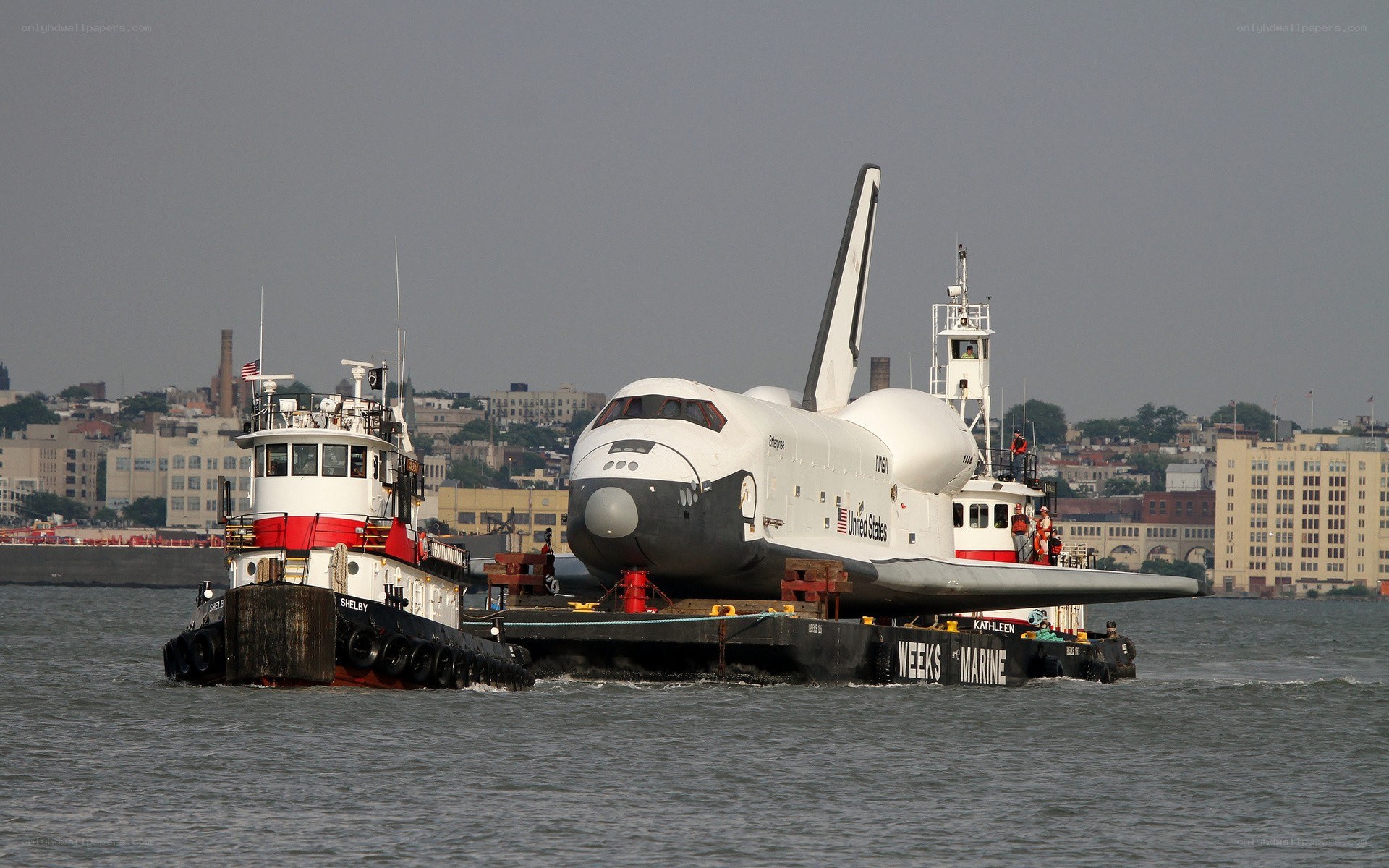 Space shuttle being transported by tugboats