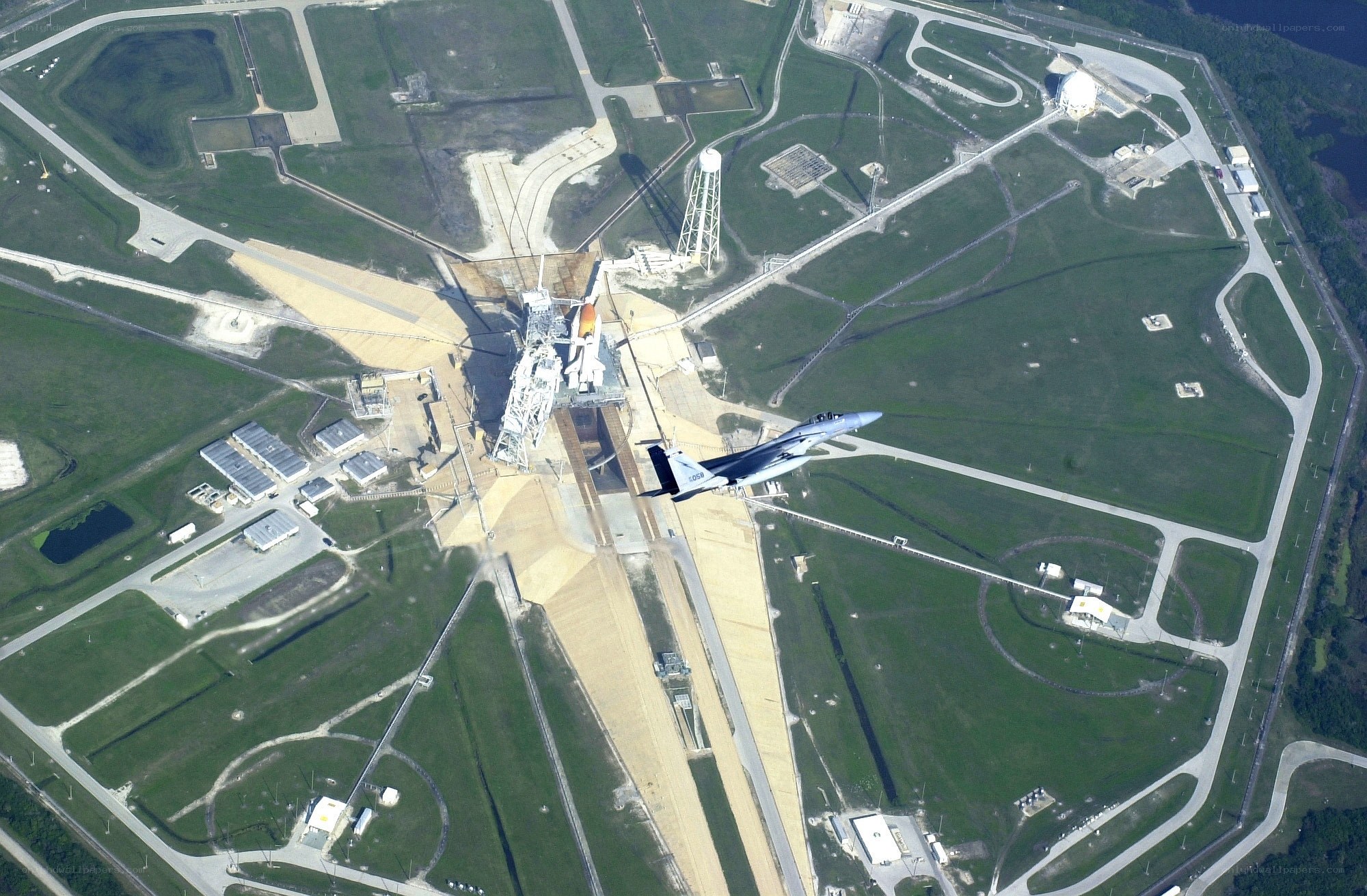 Space Shuttle launch site with fighter jet