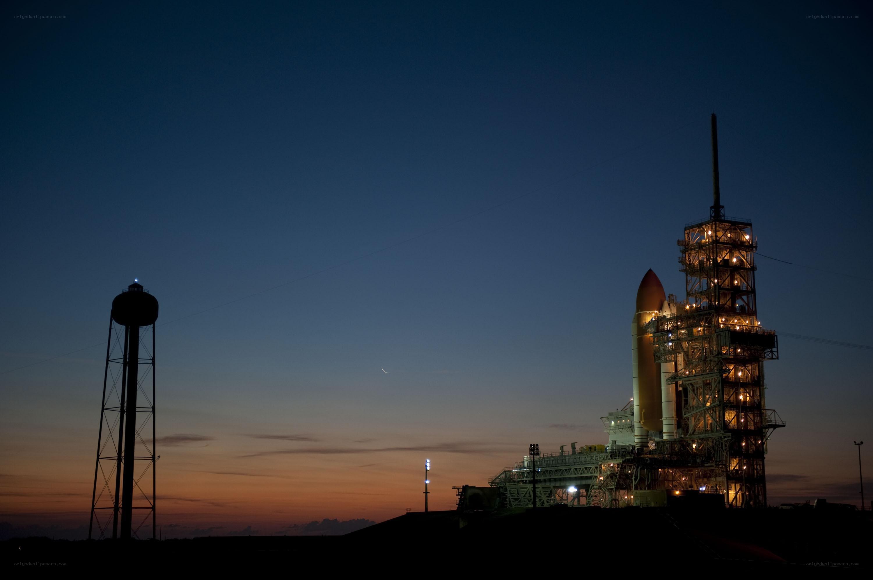 Space shuttle on launch pad at dusk