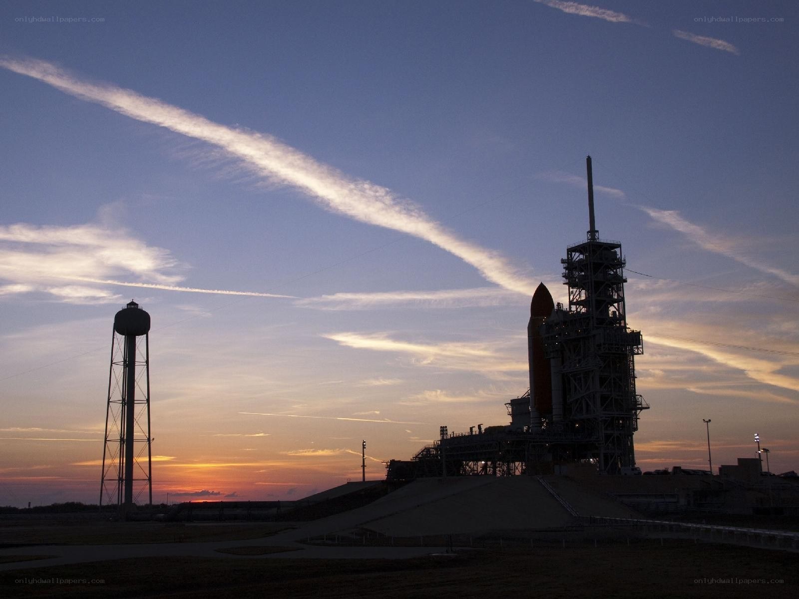 Space shuttle on launch pad at dusk