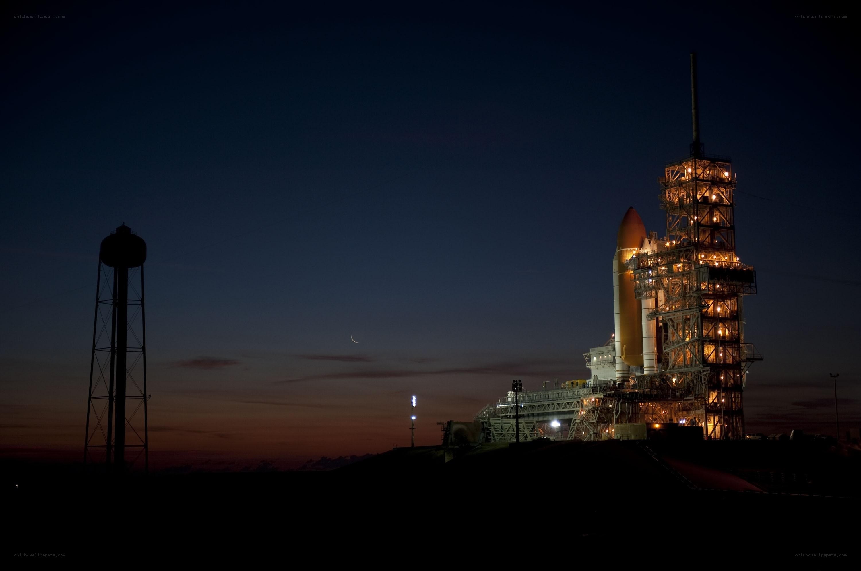 Space shuttle on launch pad at dusk