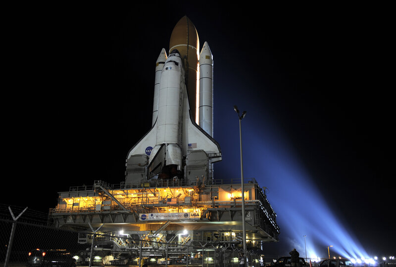 Space shuttle on launch pad at night