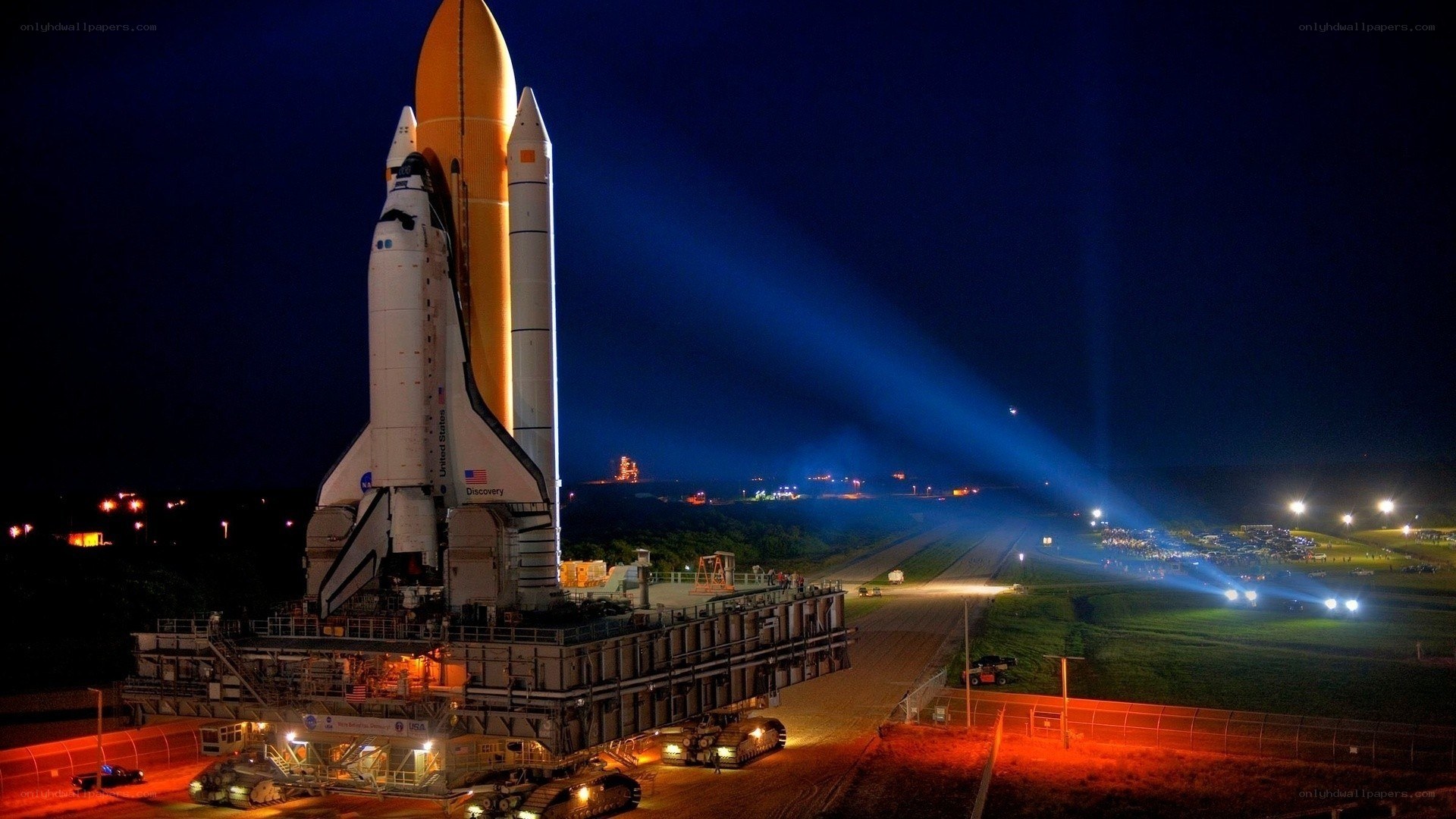 Space shuttle on launch pad at night