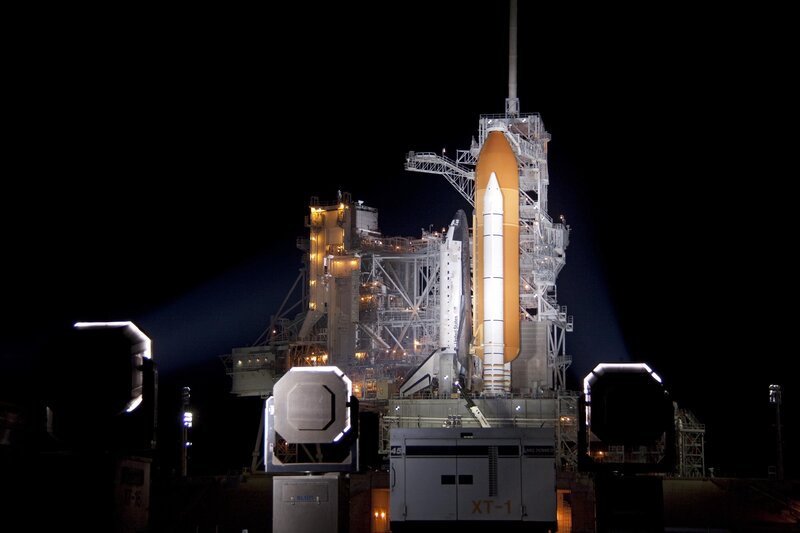 Space shuttle on launch pad at night