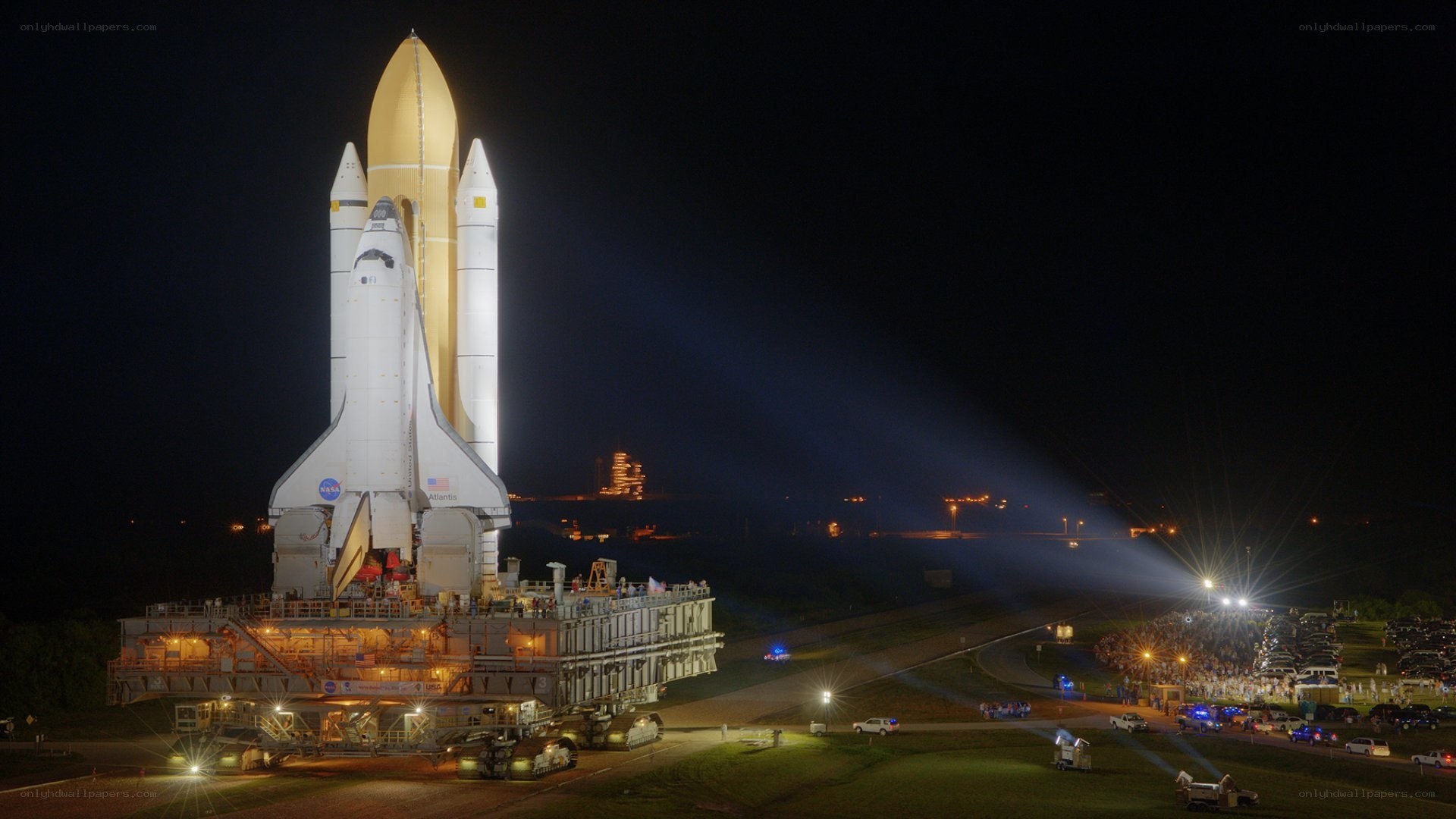 Space shuttle on launch pad at night