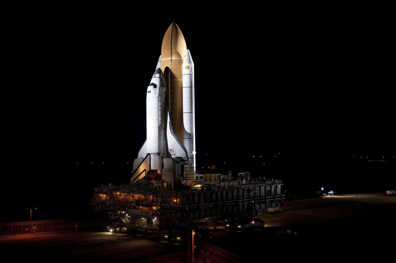 Space shuttle on launch pad at night