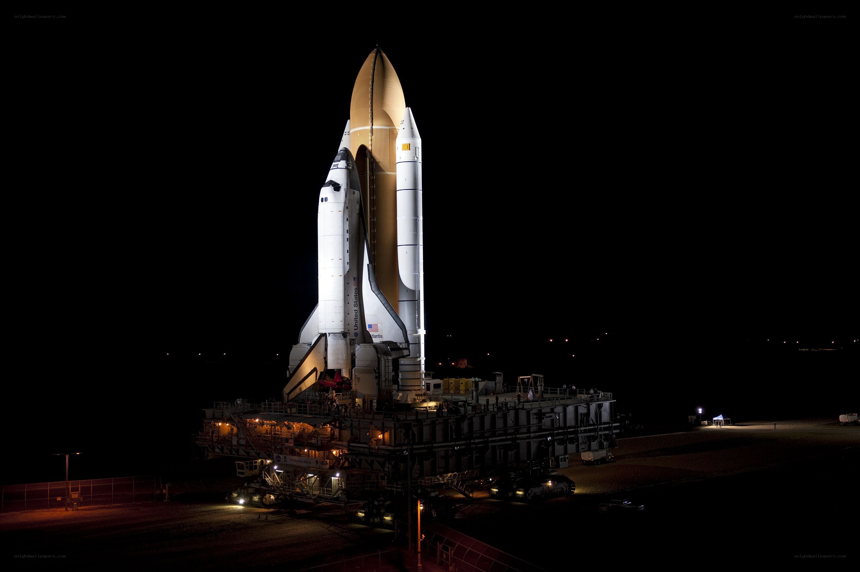 Space shuttle on launch pad at night
