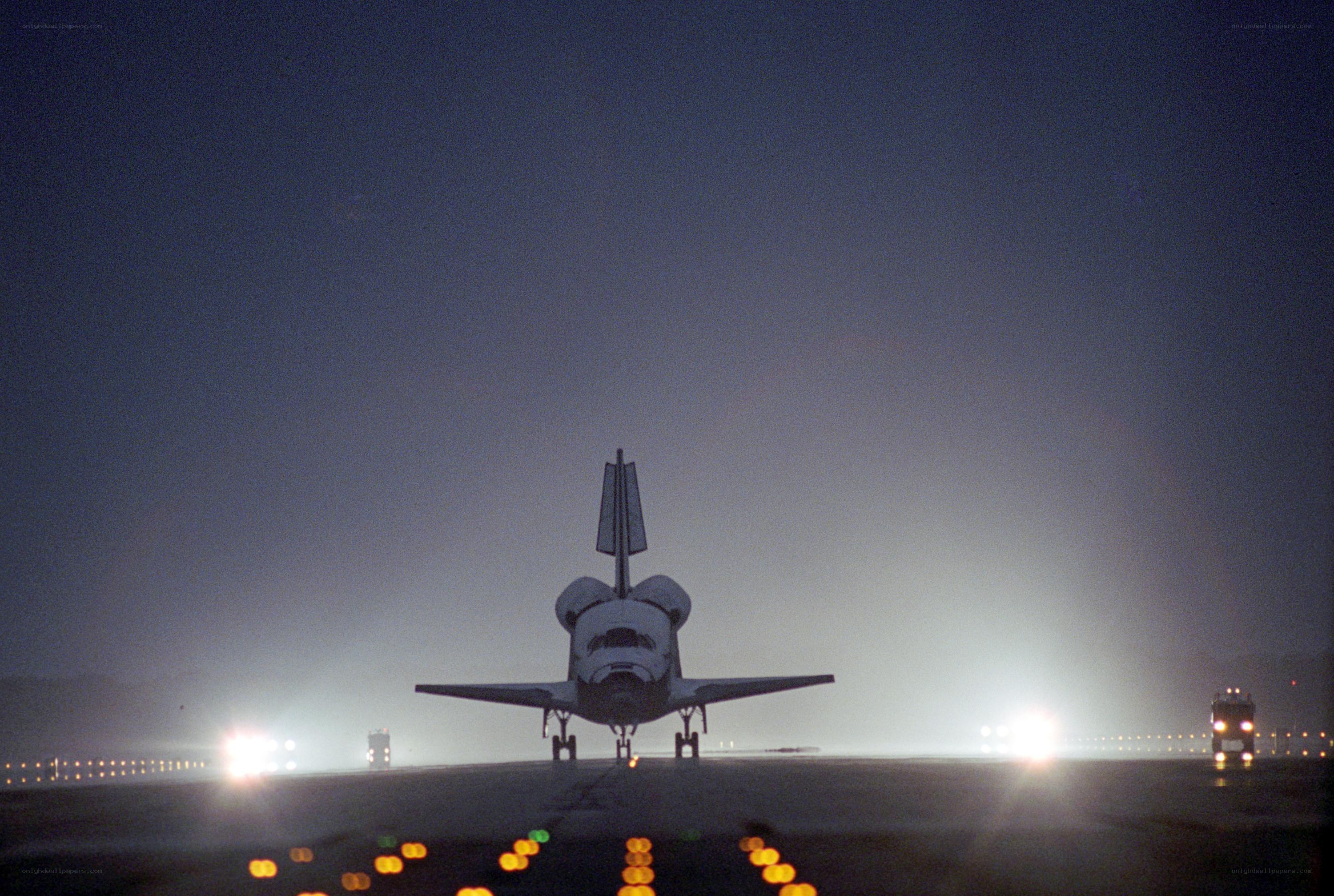 Space shuttle on runway at night