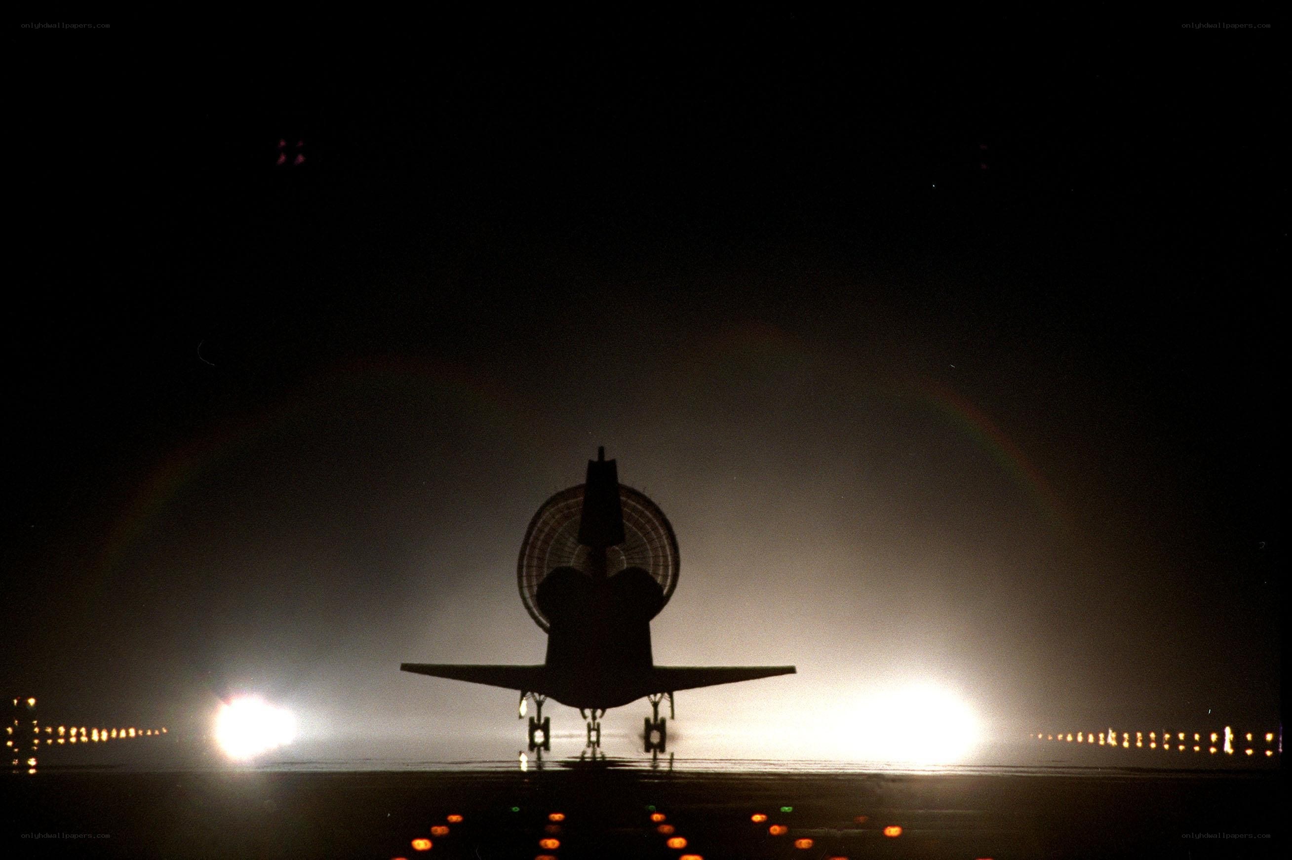 Space shuttle on runway at night