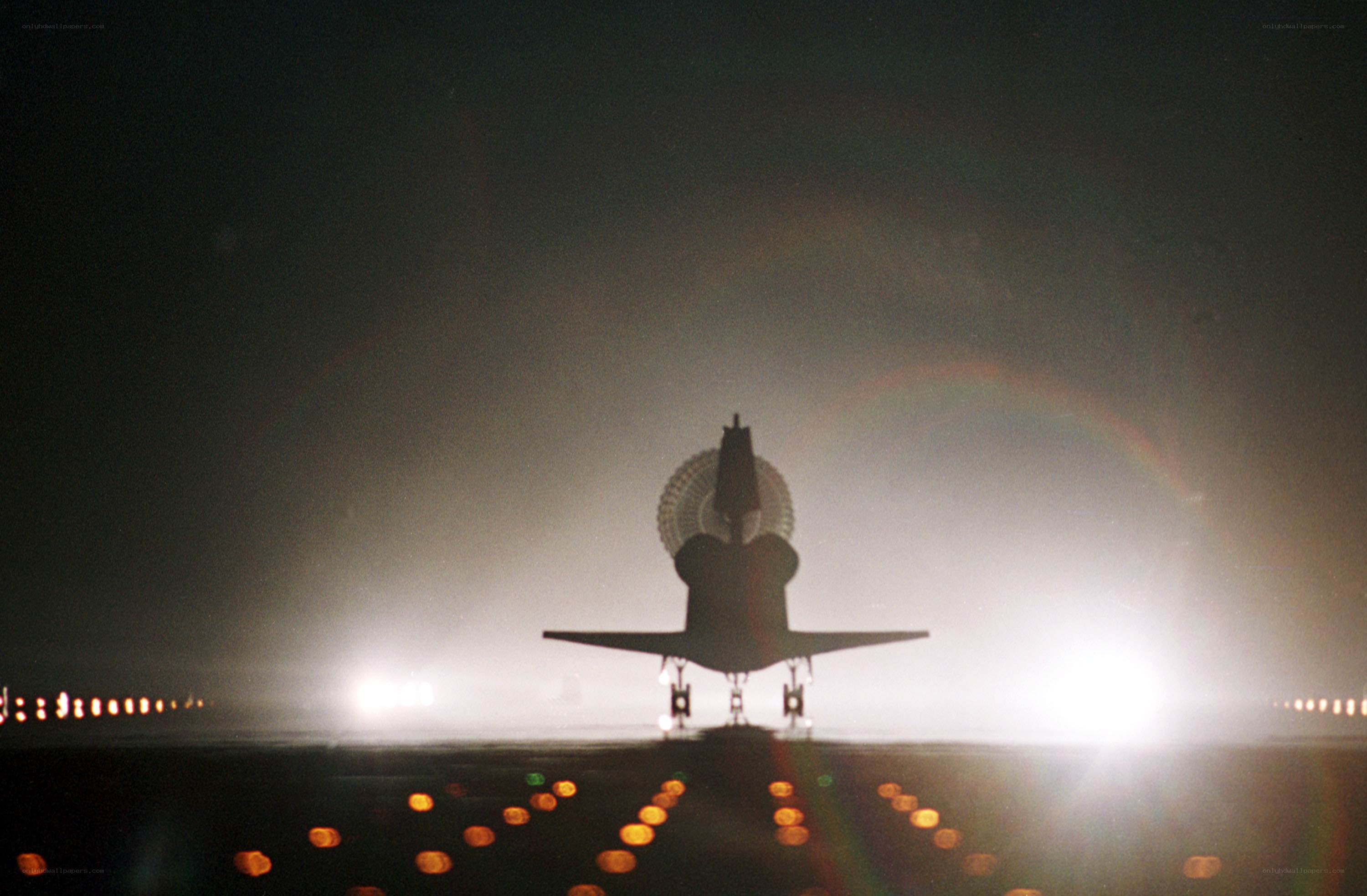 Space shuttle on runway at night