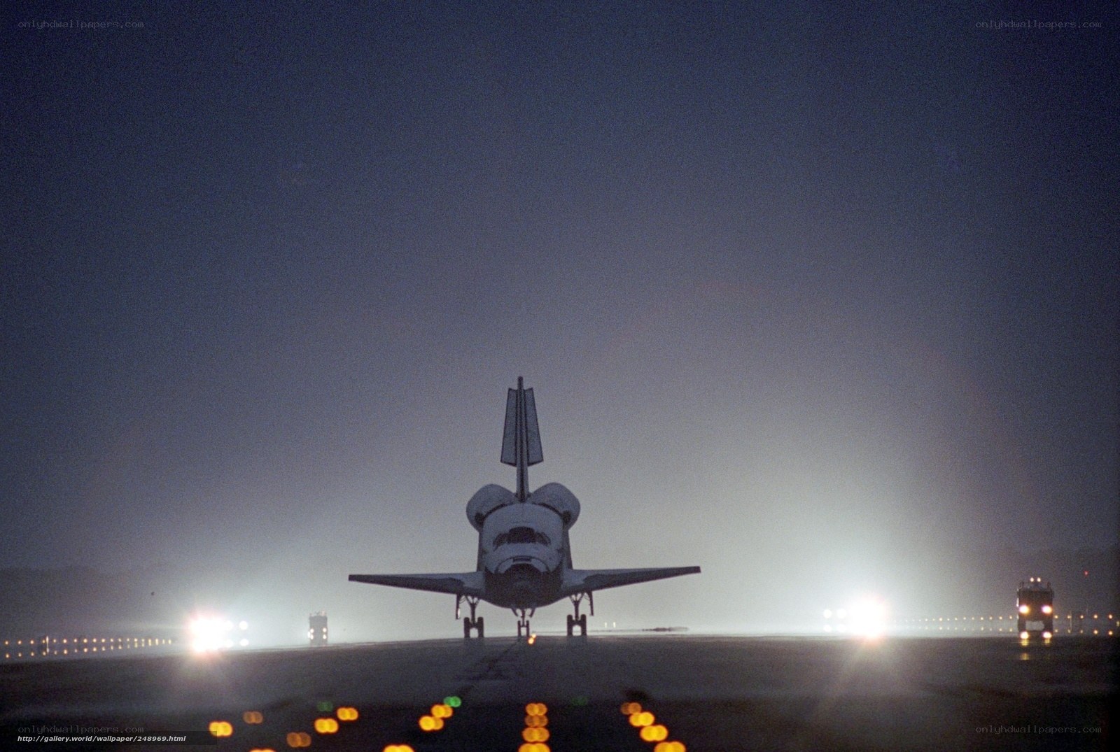Space shuttle on runway at night