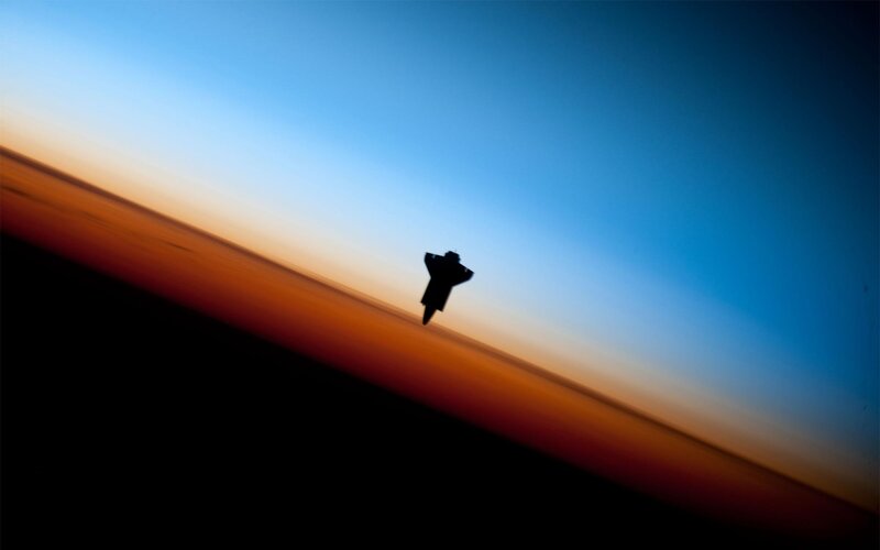 Space shuttle silhouette at sunset