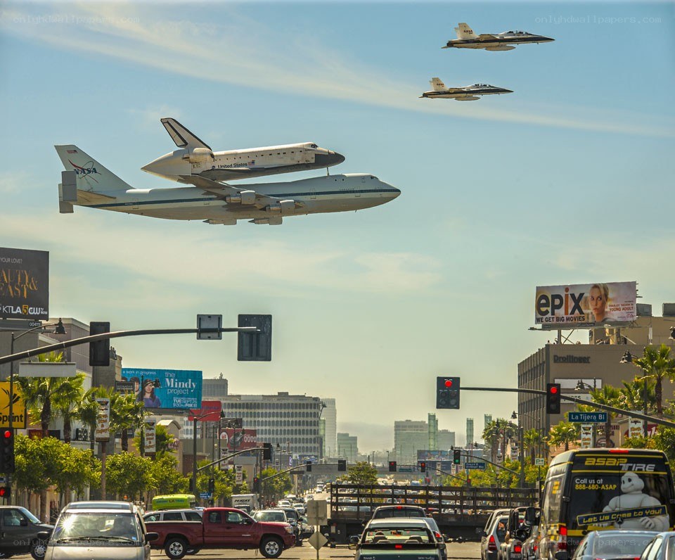 Space shuttle transport over city