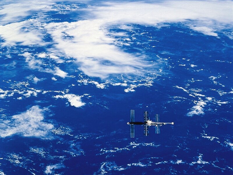 Space Station Orbiting Earth — Blue, Serene, Photograph, Clouds, Satellite